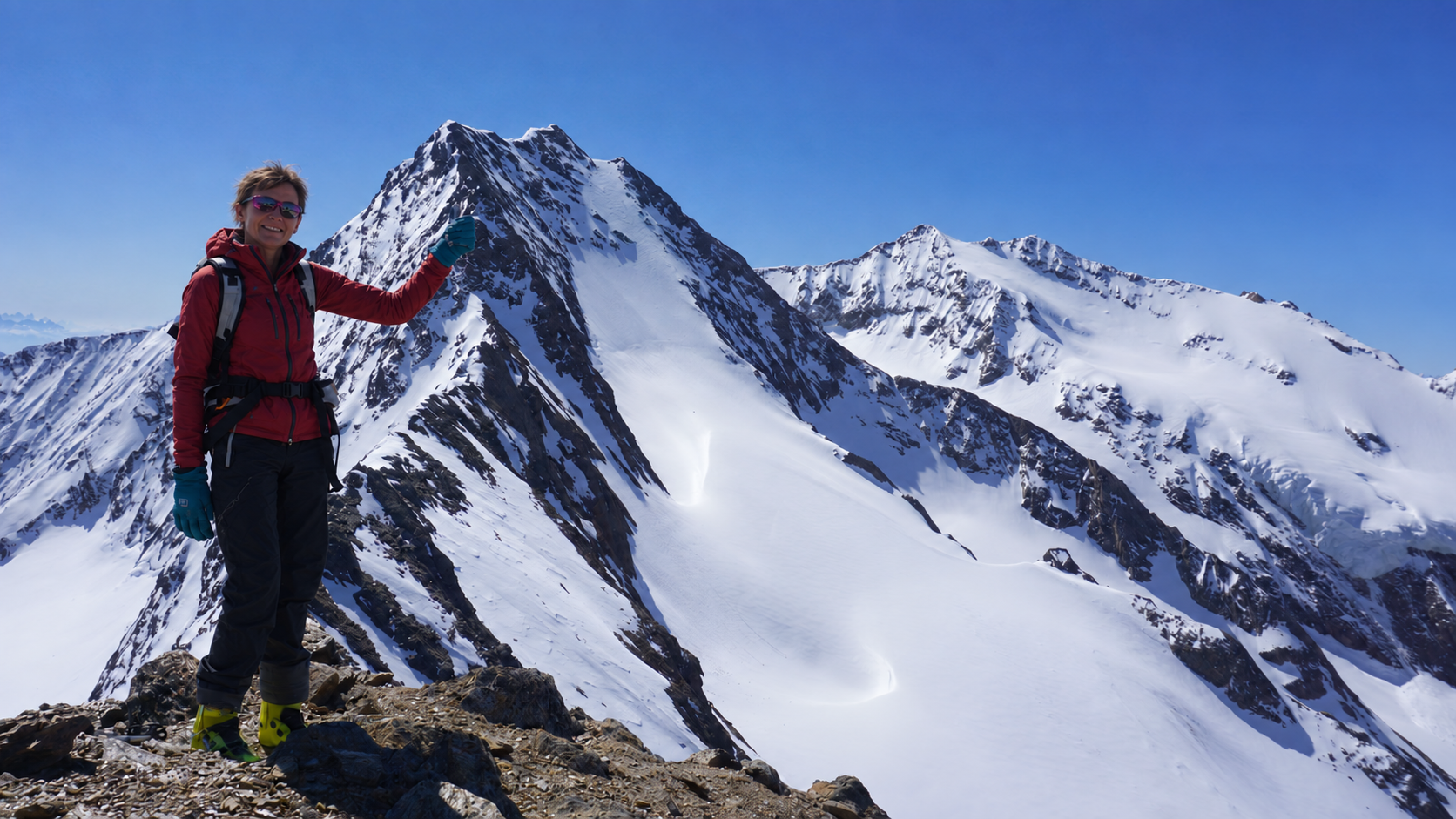 Ski tourer on the summit ridge with the snow-covered Essener Spitze behind her
